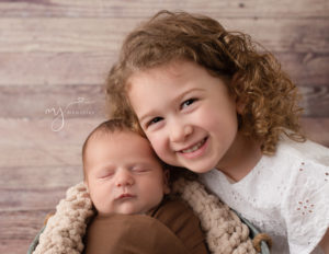 Sweet newborn boy posed with his big sister in our studio.