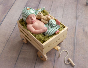 Newborn boy posed in wagon in our studio in Rochester, NY.