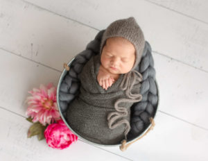 Sweet newborn posed in a bucket in our Rochester, NY studio.