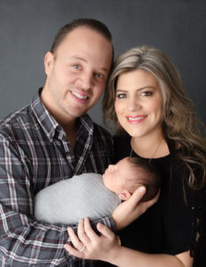 Newborn with parents posed at our studio in Rochester, NY