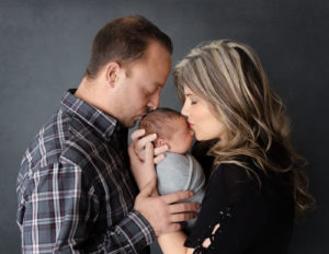 Parents with newborn posed at our studio in Rochester, NY.