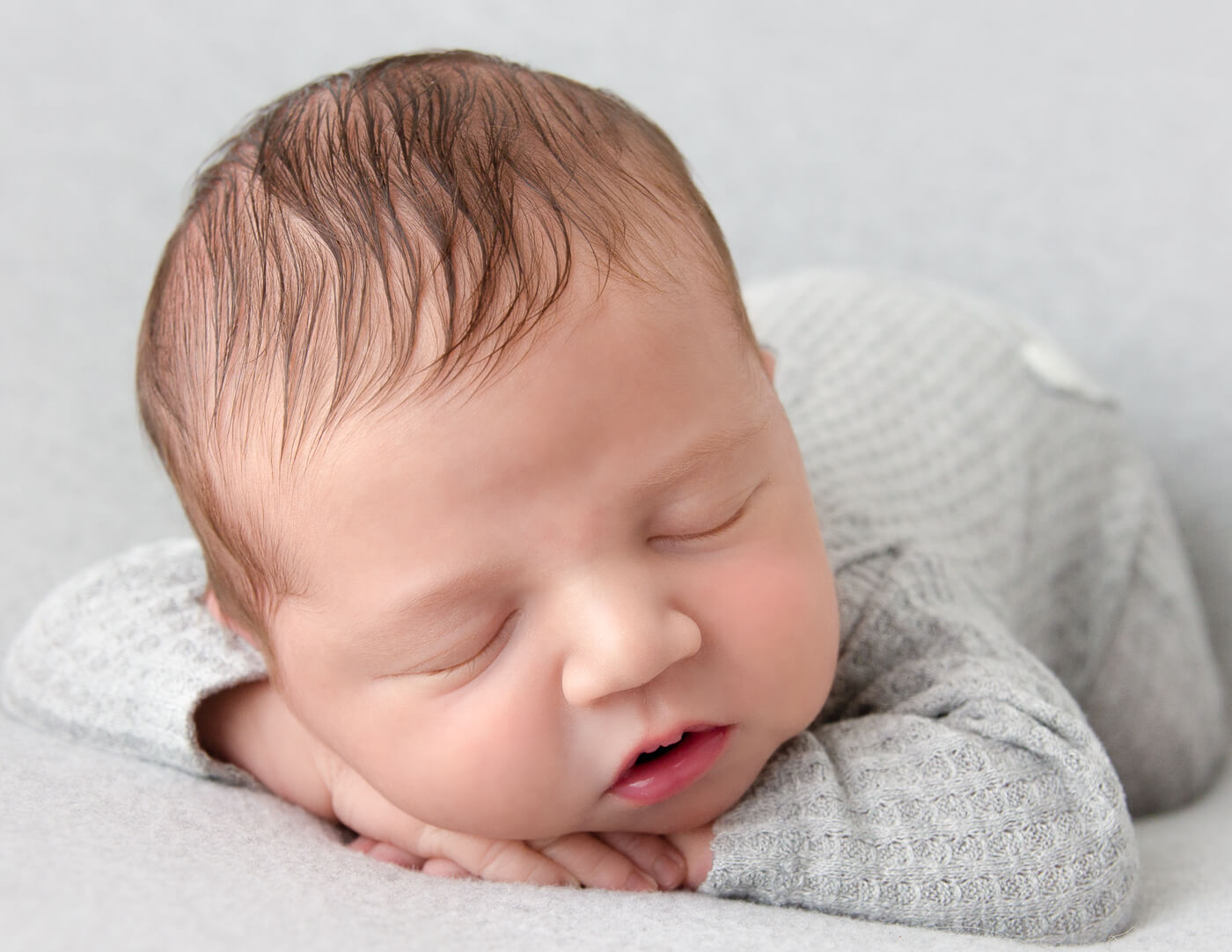 Sleeping newborn boy posed in our studio in Rochester, NY.