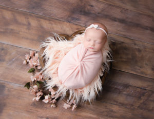 Precious newborn girl posed at our Rochester, NY studio.