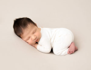 Posed sleeping newborn at our Rochester, NY studio.