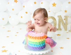 Crying girl at her cake smash in our studio.