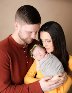 Newborn with parents posed at our studio in Rochester, NY