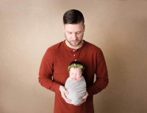 Dad and newborn girl posed in our Rochester, Ny studio.