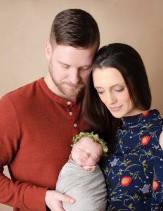 Newborn with parents posed at our studio in Rochester, NY