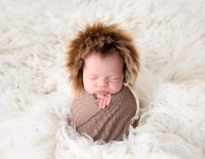 Sleeping newborn girl posed in our studio in Rochester, NY.