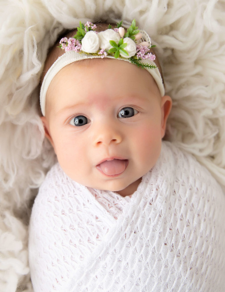 Awake2 month newborn girl posed at our in-home Rochester, NY studio.