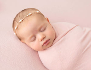 Precious newborn girl posed at our Rochester, NY studio.