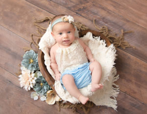 Awake 2 month newborn girl posed at our Rochester, NY studio.