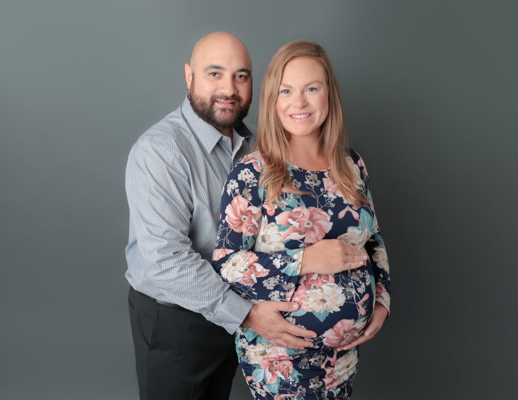 Expecting mother & father posing gracefully for a maternity photoshoot at MJ Memories studio in Rochester, NY, capturing the beauty of motherhood