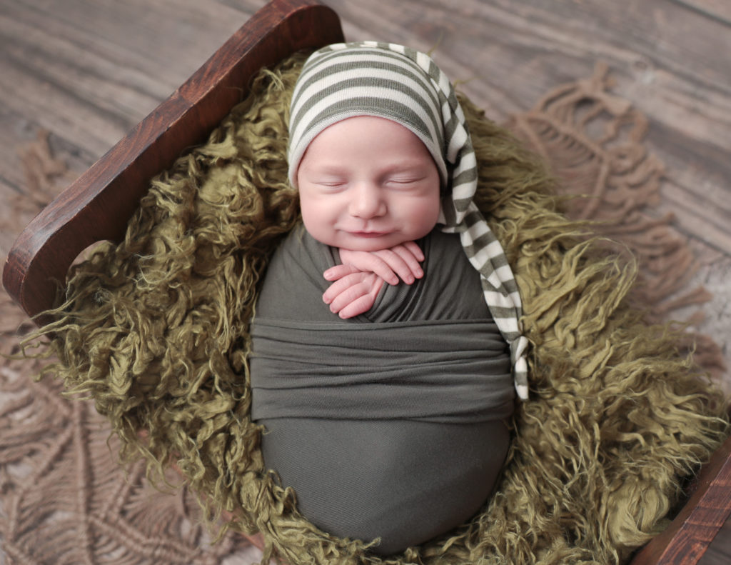 Smirking newborn boy at our studio in Rochester, NY