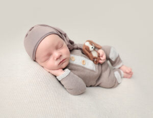 Baby boy holding a doggy stuffy, Rochester Newborn Photography.