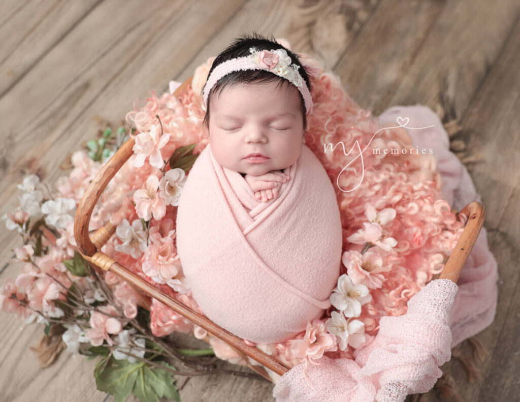 A beautiful newborn baby girl surrounded by pastel florals was captured at MJ Memories Photography studio in Rochester, NY.