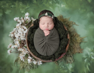 Newborn baby girl adorned with floral accents in a photography session at MJ Memories Photography studio in Rochester, NY