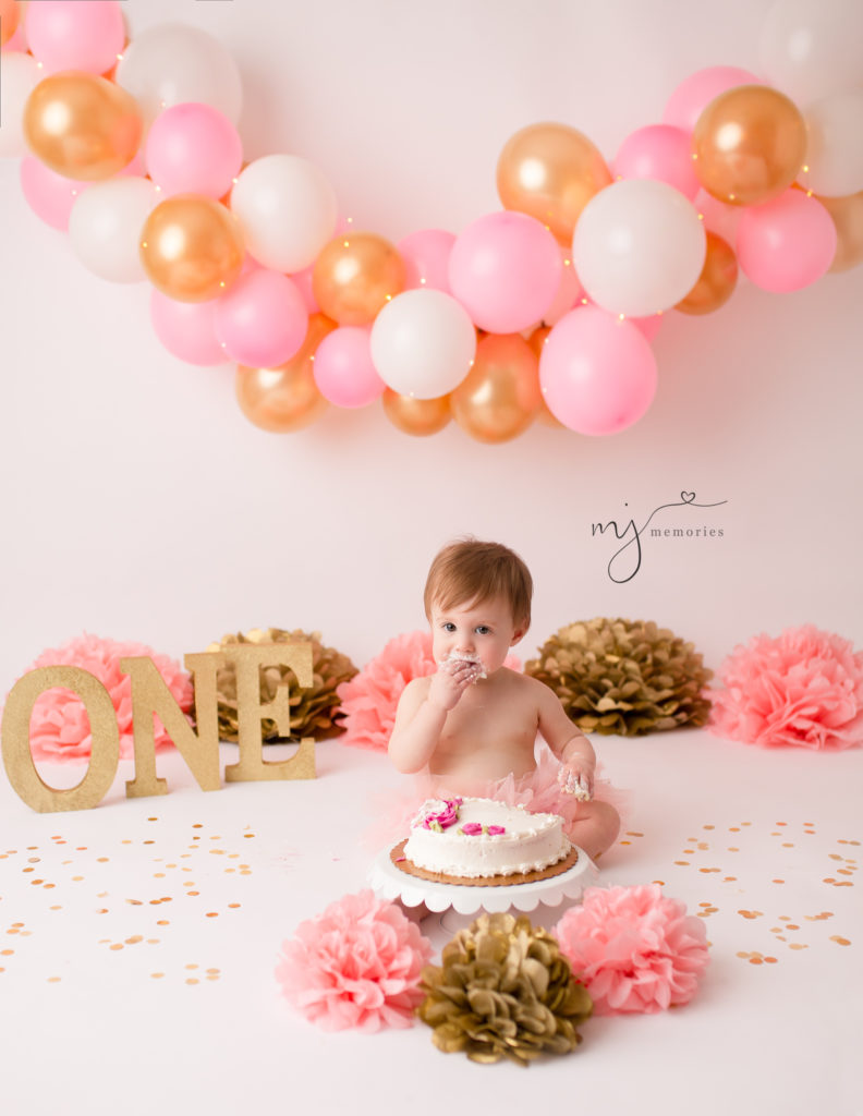 One year old girl eating cake at our Rochester, Ny studio.