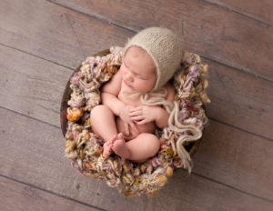 Infant girl posed in a wooden bowl in Rochester, NY.