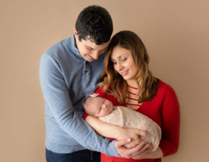 Sweet parents posed with their infant in Rochester, NY.