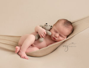 Precious newborn boy posed with a bear at his photo session in Rochester, NY