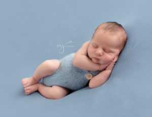 Cute newborn boy posed at his photo session in our Rochester, NY studio.