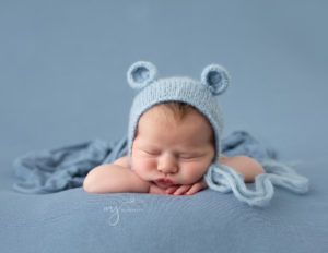 Newborn boy in head on hands pose in our in-home Rochester, NY studio.