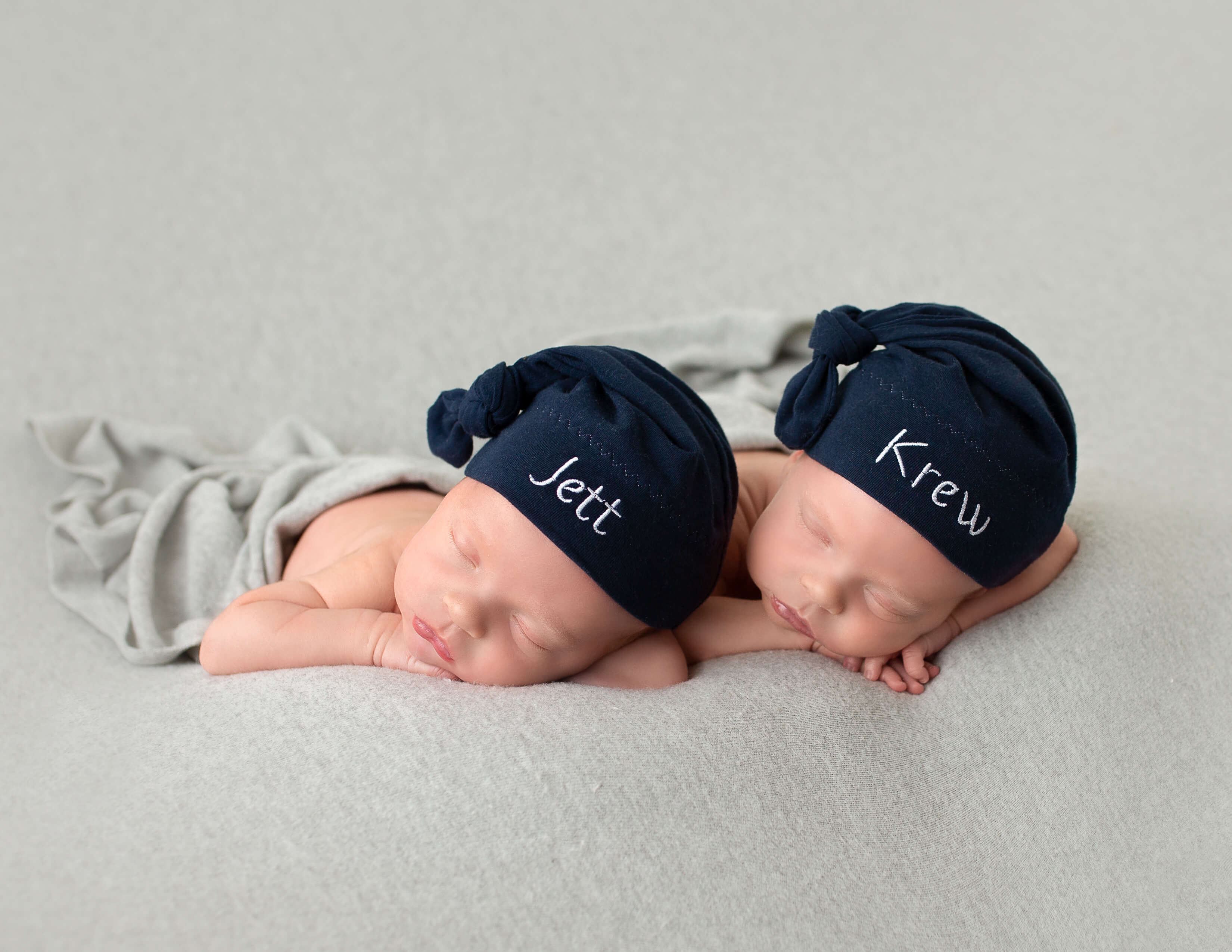 Twin newborn boys posed head on heads in our in home studio in Rochester, Ny.