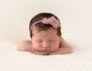 Precious newborn girl posed sleeping in our studio in Rochester, Ny.