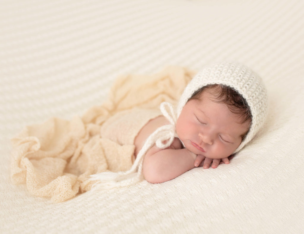 Sweet newborn girl in head on hands pose in our Rochester, Ny studio.