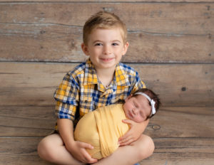 Big brother posed with newborn in our studio in Rochester, NY.