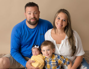 Family posed with newborn in our studio in Rochester, Ny.