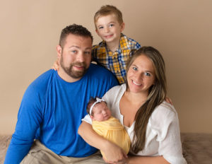 Family posed with newborn in our Rochester, Ny studio.