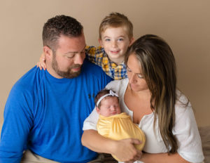 Family posed with newborn in our Rochester, Ny studio.
