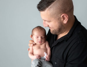 Father and newborn posed in our Rochester, NY studio.
