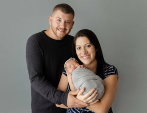 Family posed with baby at our Rochester, NY studio.