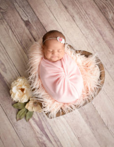 Sleeping baby posed in wooden heart bowl in our Rochester, NY studio.