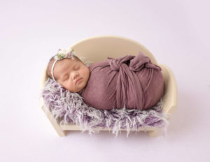 Sweet newborn posed on baby couch in our Rochester, NY studio.