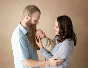 Parents and newborn posed at our studio in Rochester, NY.