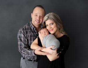 Parents with newborn posed at our studio in Rochester, NY.