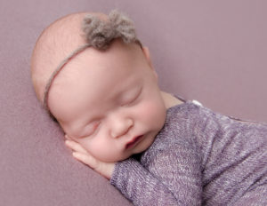 Cute newborn baby girl posed at our studio in Rochester, NY.