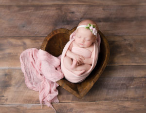 Newborn girl posed at our Rochester, NY studio.