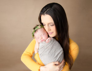 Mother posed with newborn in our Rochester, Ny studio.