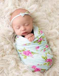 Sleeping newborn girl posed in our studio in Rochester, NY.