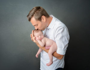 Father and newborn posed at our Rochester, NY studio.