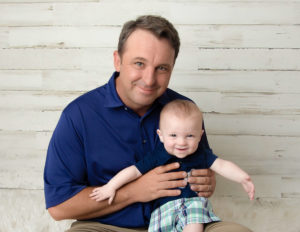 Dad posed with baby boy at our Rochester, NY studio.