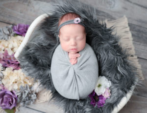 Cute girl posed at her newborn family session in our Rochester, NY studio.