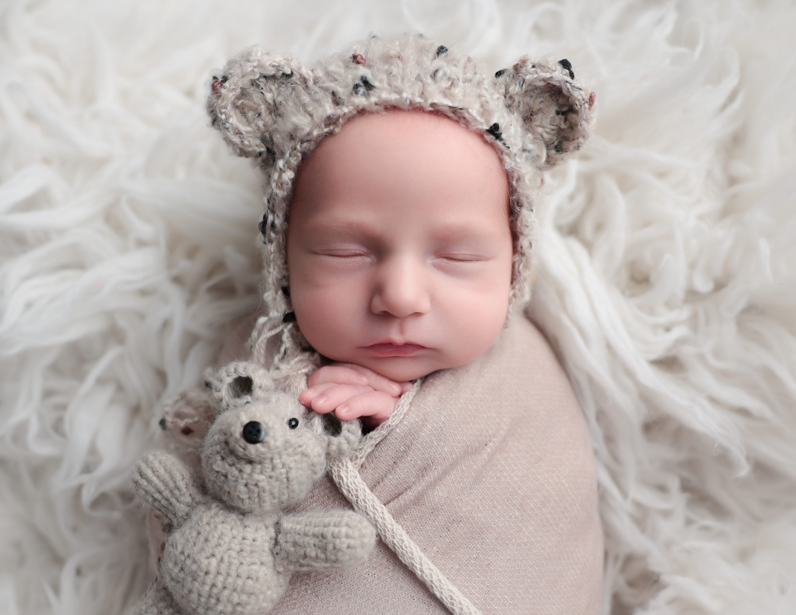 Teddy bear bonnet on a newborn boy